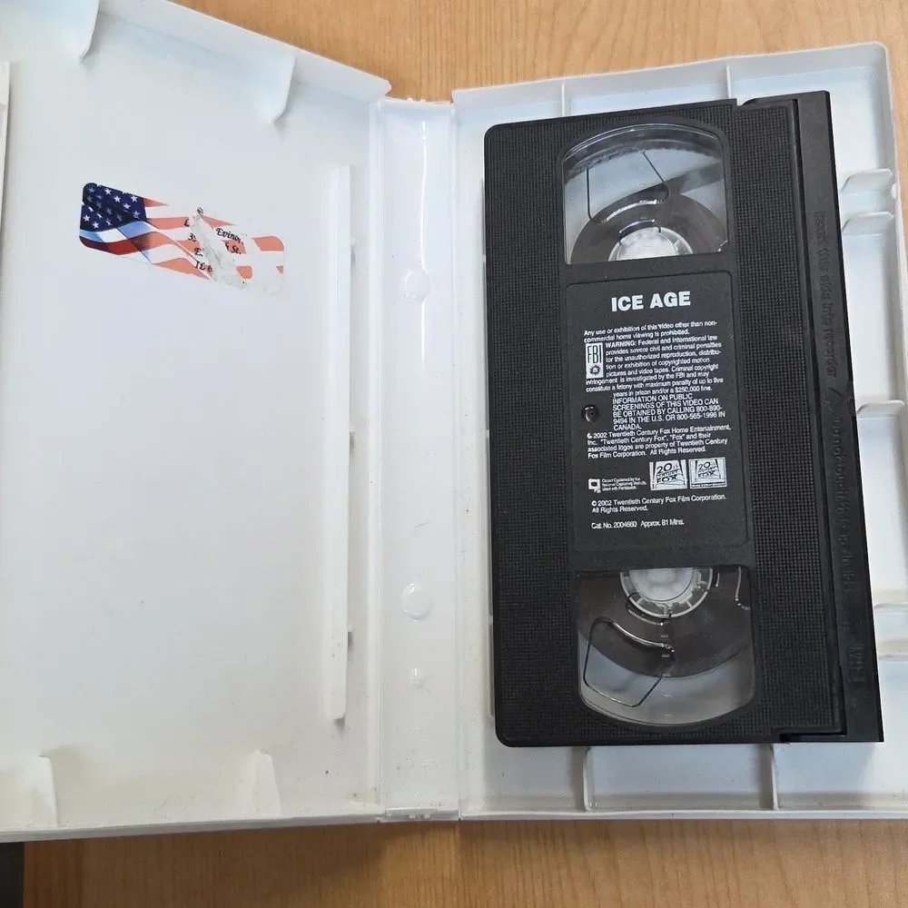 collection of Ice Age merchandise, including a VHS tape, two DVDs, Sid the Sloth